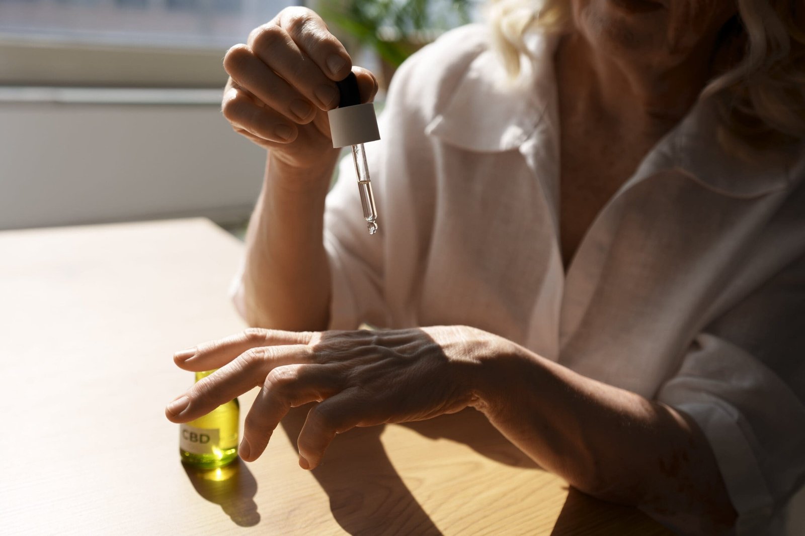 primer plano mujer usando aceite cbd mano min 1 scaled